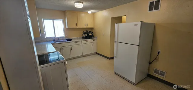 a kitchen with white cabinets and white appliances