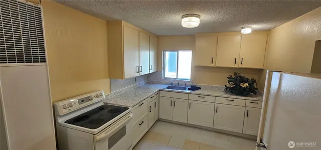 a kitchen with a refrigerator sink stove and cabinets