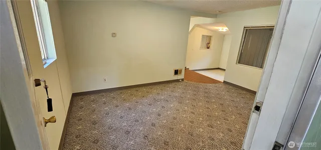 a view of a hallway with wooden floor and a living room