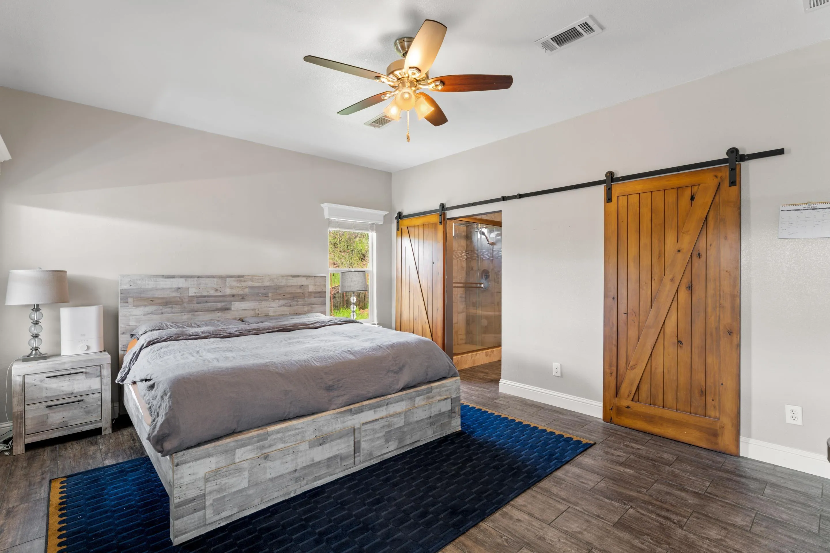 3505 Alpine Boulevard, Unit 1 Alpine, CA 91901 - Photo 17 of 27 a bedroom with a large bed and a chandelier