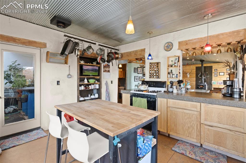 54309 County Rd LL56 Villa Grove, CO 81155 - Photo 14 of 43 a kitchen with a stove a refrigerator and a dining table with wooden floor
