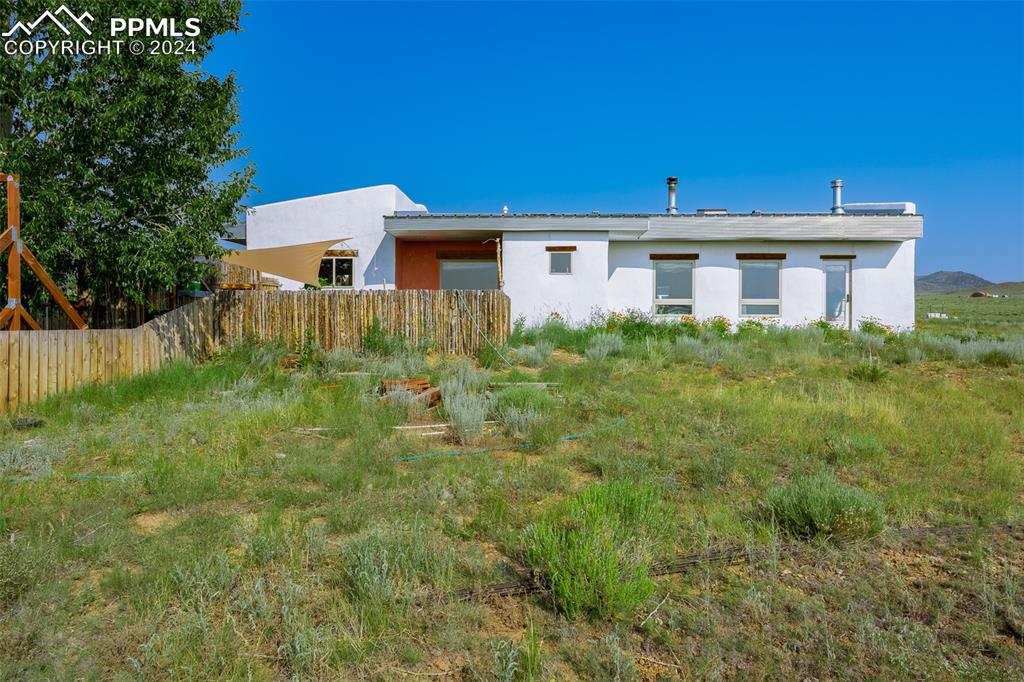 54309 County Rd LL56 Villa Grove, CO 81155 - Photo 3 of 43 a view of a yard in front of a house with plants and large trees