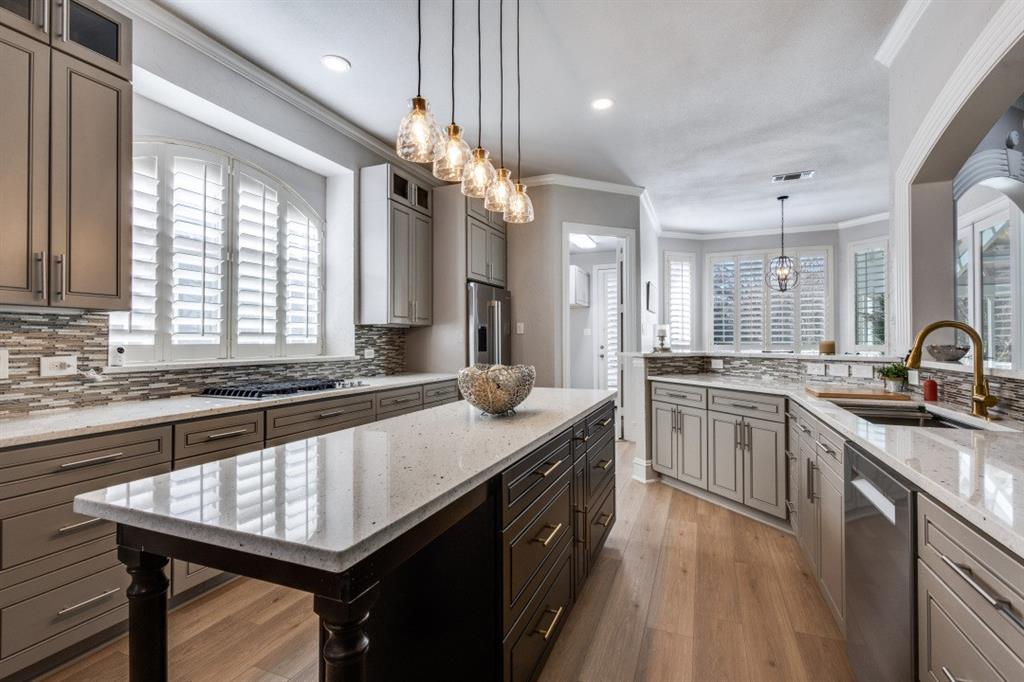 3512 Provine Road McKinney, TX 75072 - Photo 14 of 33 a large kitchen with a center island wooden floor stainless steel appliances and windows