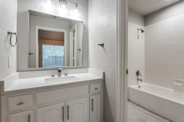 a bathroom with a tub sink and mirror