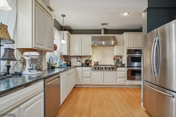 a kitchen with stainless steel appliances a refrigerator sink and microwave