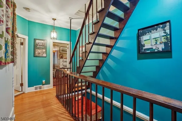 a view of staircase with lots of frames on wall and a large window