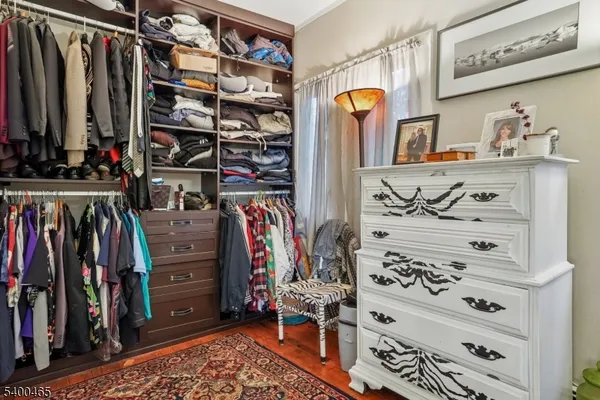 a view of walk in closet with clothes and shoes