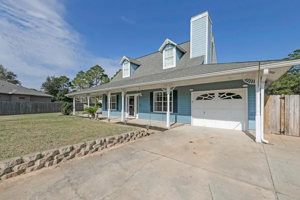 a front view of a house with a garden and yard