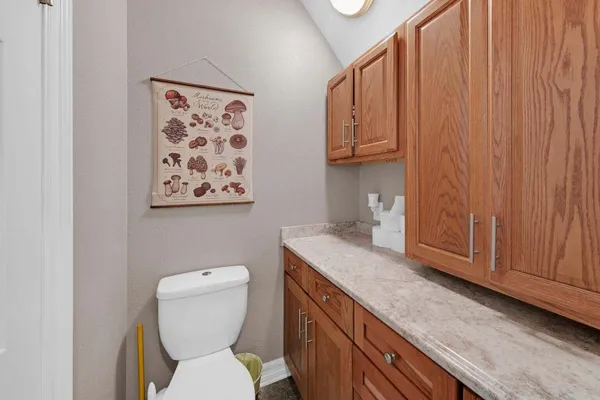 a bathroom with a granite countertop toilet and a sink