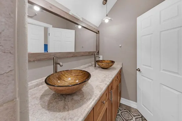 a bathroom with a granite countertop sink and mirror