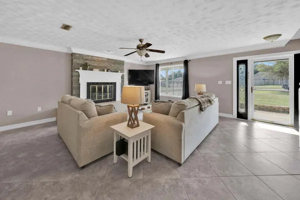 a living room with furniture a fireplace and a chandelier