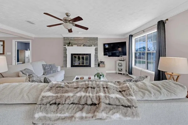 a living room with furniture a flat screen tv and a fireplace