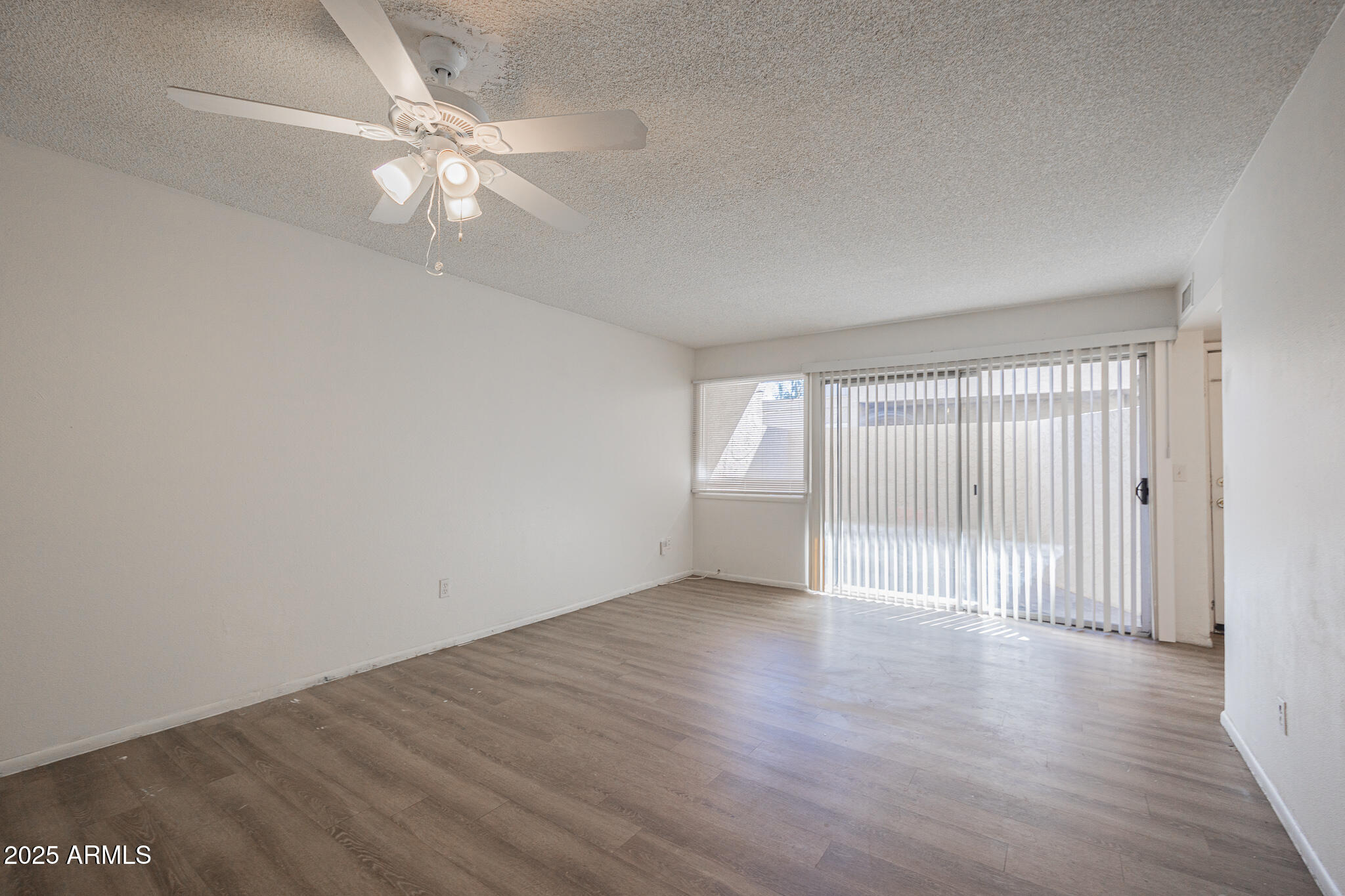 2802 North 43rd Avenue, Unit B Phoenix, AZ 85009 - Photo 5 of 18 wooden floor in an empty room with a window