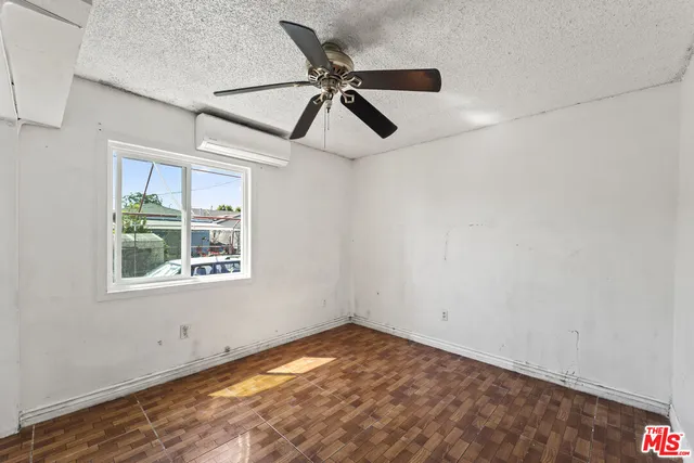 an empty room with a window and a fan