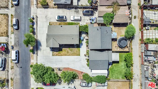 an aerial view of residential houses with outdoor space and parking