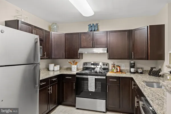 a kitchen with stainless steel appliances a sink a stove a refrigerator and cabinets