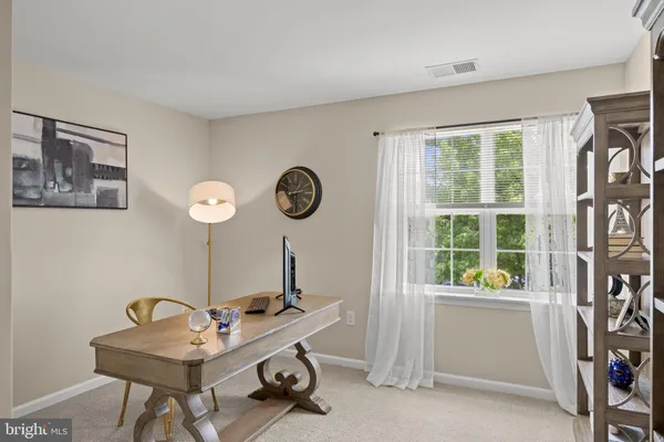 a view of a workspace with furniture and a window