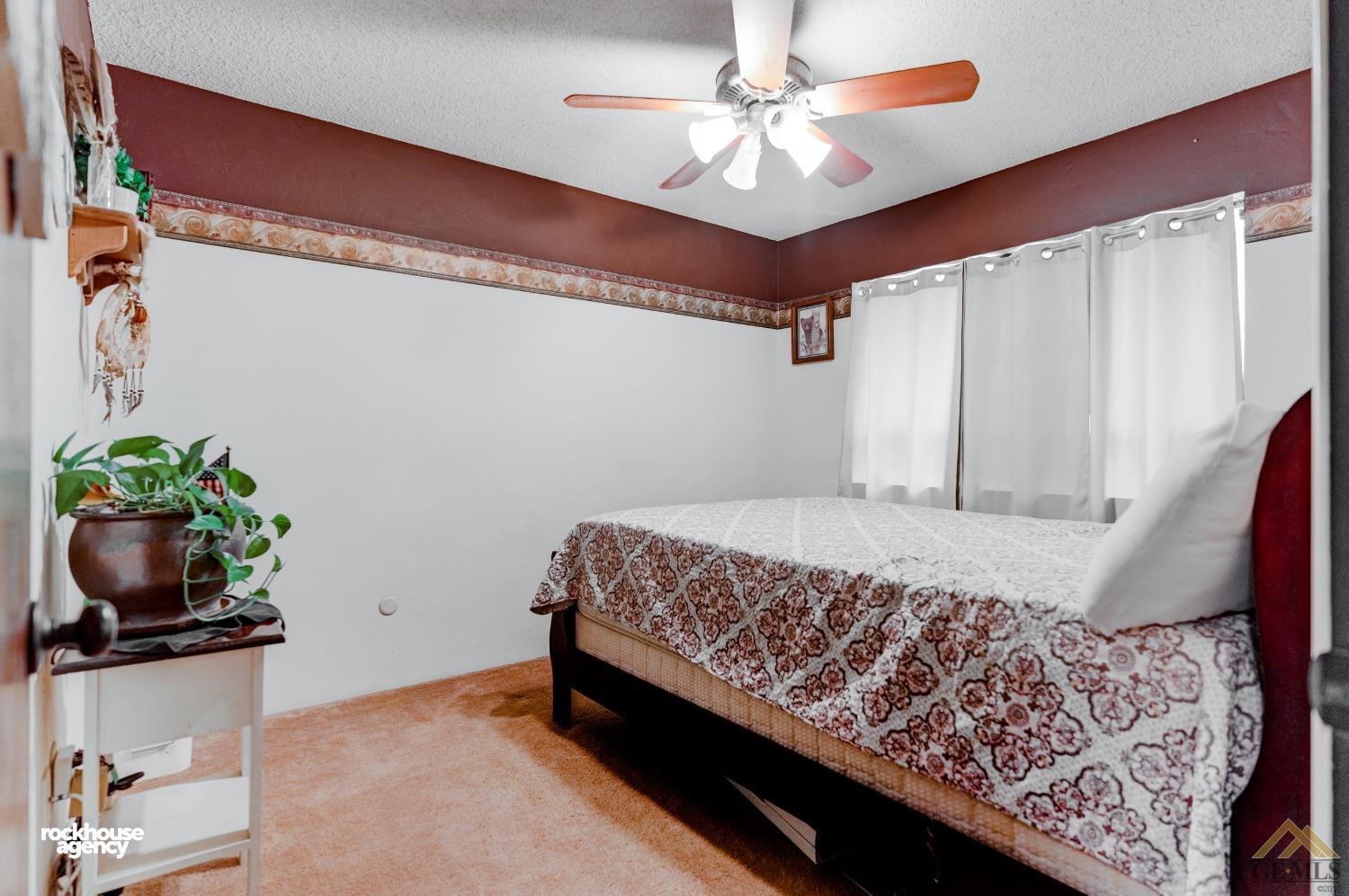Undisclosed Address Bakersfield, CA 93308 - Photo 15 of 22 a bedroom with a bed and a chandelier