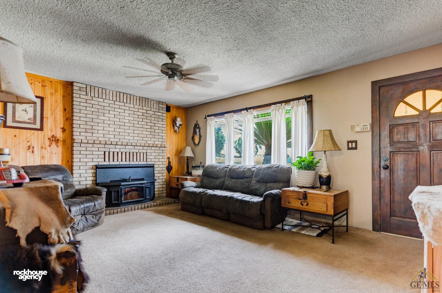 Undisclosed Address Bakersfield, CA 93308 - Photo 5 of 22 a living room with furniture a fireplace and a table