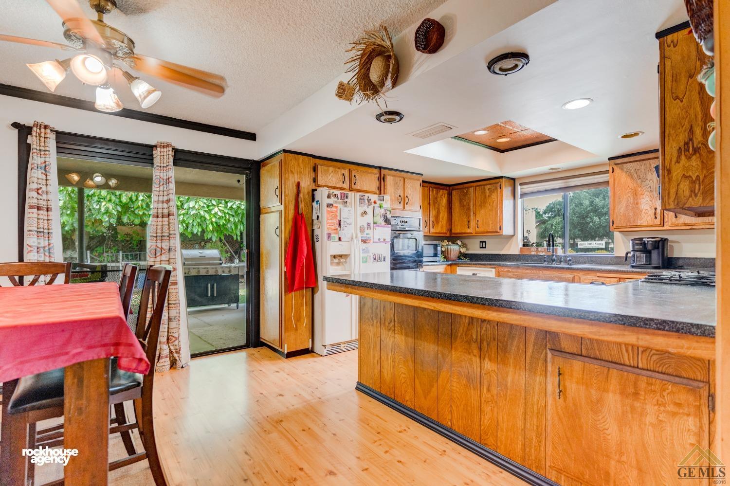 Undisclosed Address Bakersfield, CA 93308 - Photo 8 of 22 a kitchen with stainless steel appliances kitchen island granite countertop a refrigerator a stove and a sink with dishwasher next to a window