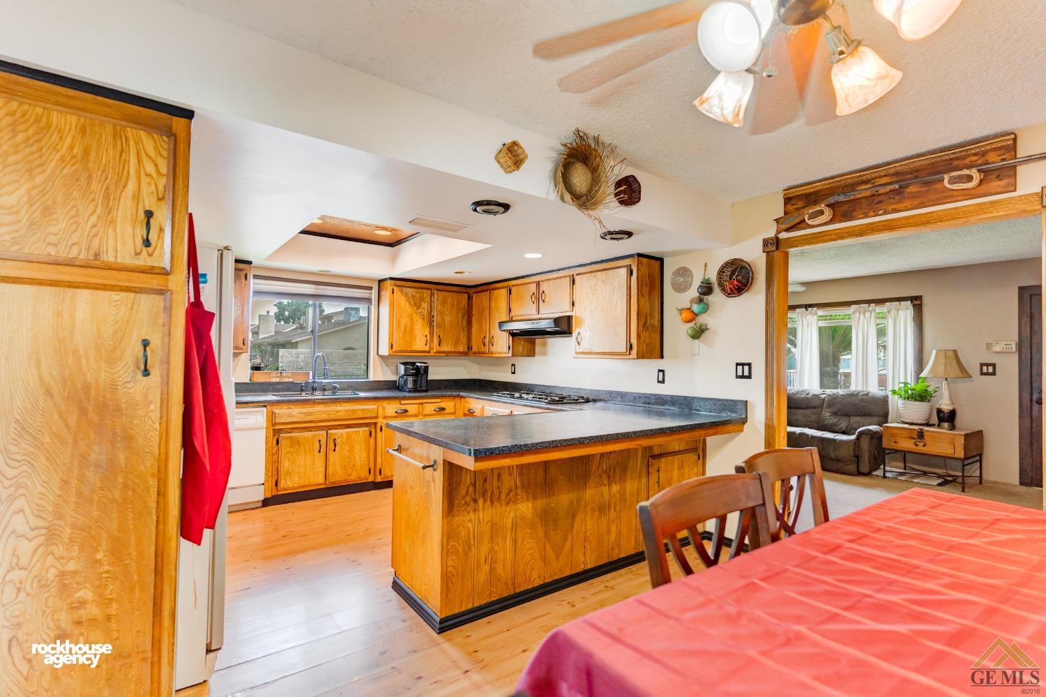 Undisclosed Address Bakersfield, CA 93308 - Photo 10 of 22 a kitchen with stainless steel appliances granite countertop a stove and a view of living room