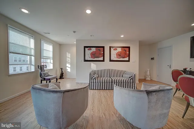 a living room with furniture wooden floor and a painting