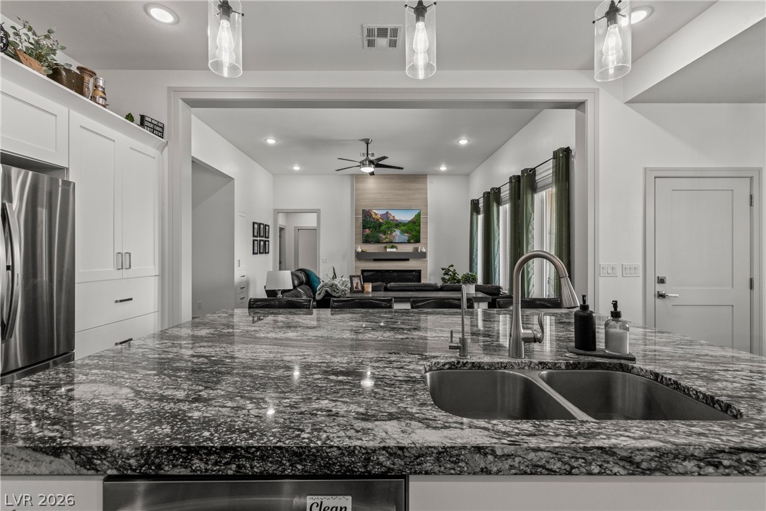 3020 Hannig Street Logandale, NV 89021 - Photo 12 of 75 A well-appointed kitchen island with gleaming stone counters flows into a bright living area.