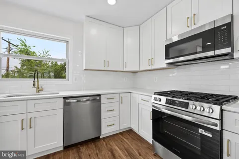 a kitchen with stainless steel appliances a stove a microwave a sink and cabinets