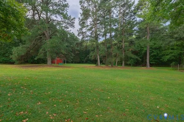 a view of a green field with trees in the background