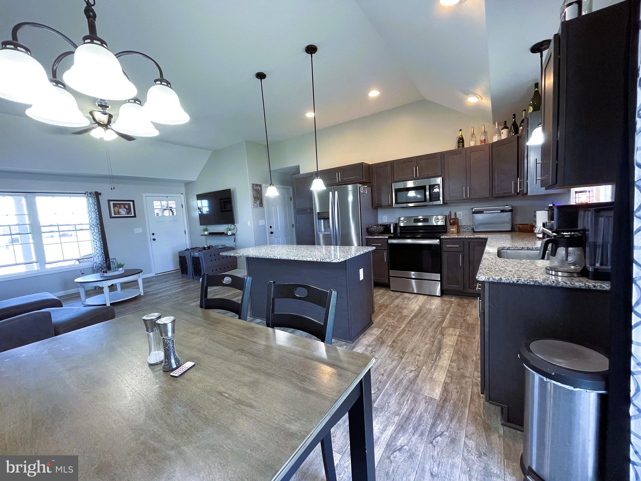 29389 Eagle Point Drive Seaford, DE 19973 - Photo 15 of 42 a kitchen with stainless steel appliances granite countertop a stove a refrigerator a oven a sink with a dining table and chairs with wooden floor