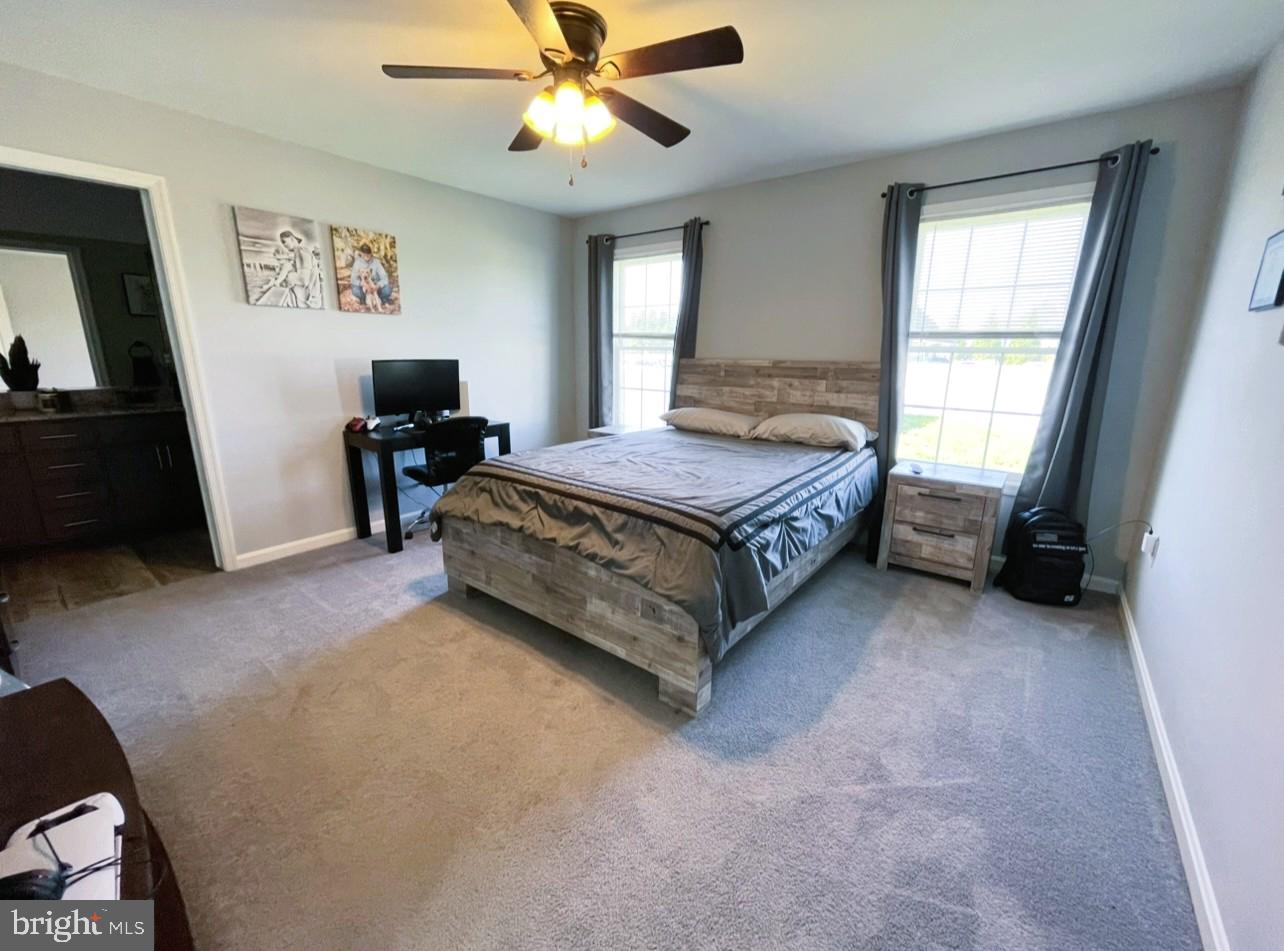 29389 Eagle Point Drive Seaford, DE 19973 - Photo 20 of 42 a spacious bedroom with a bed and a flat tv screen on dresser