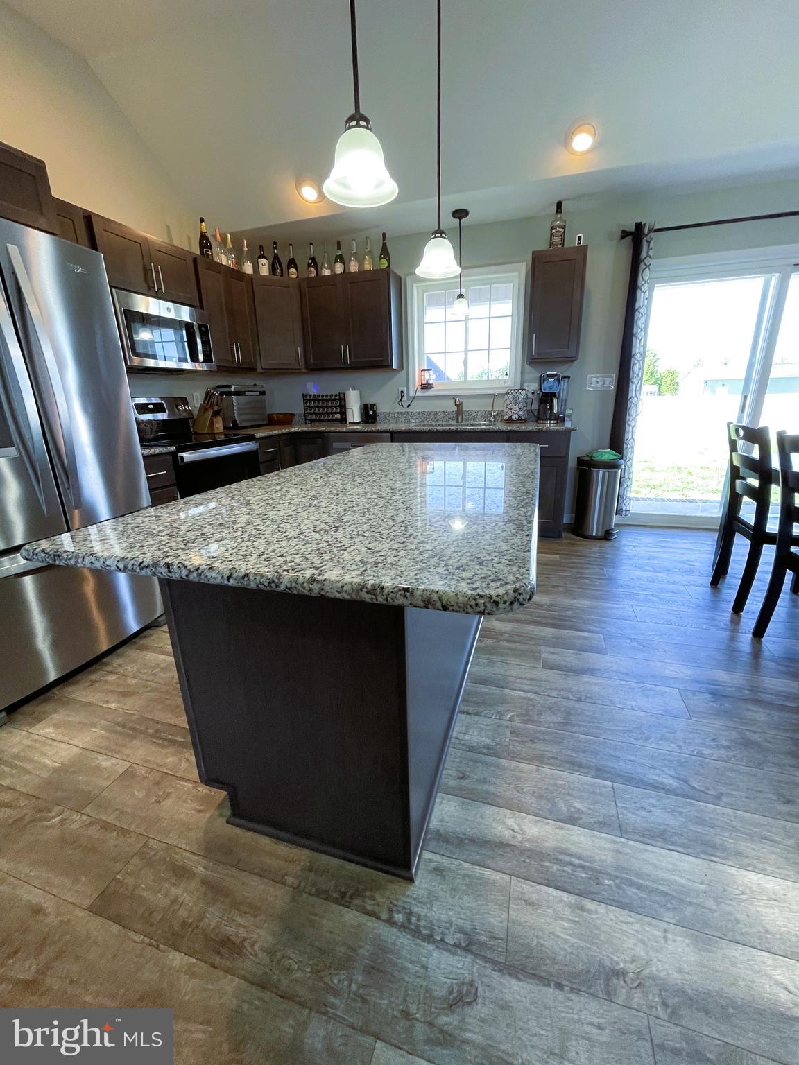 29389 Eagle Point Drive Seaford, DE 19973 - Photo 10 of 42 a large kitchen with stainless steel appliances kitchen island granite countertop a large counter top a stove a chimney a sink and a refrigerator