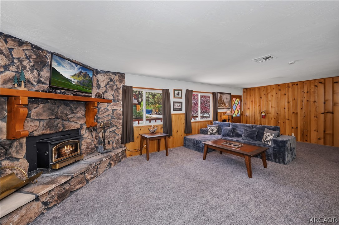 1099 Canyon Road Fawnskin, CA 92333 - Photo 10 of 39 a living room with furniture a flat screen tv and a fireplace