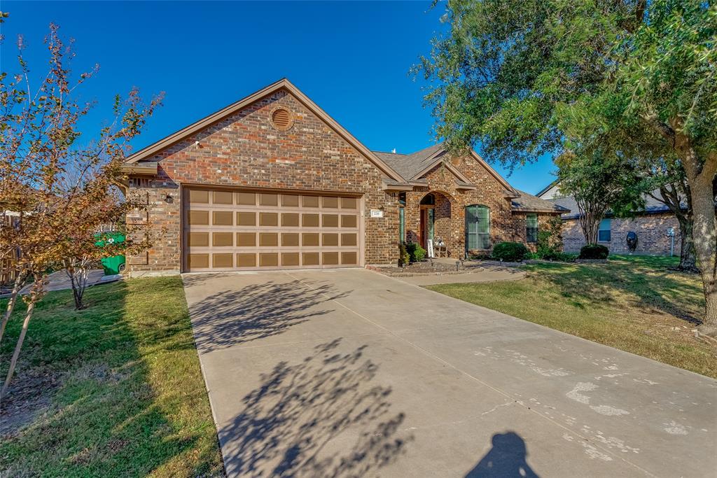 226 King George Road Ponder, TX 76259 - Photo 6 of 39 View of front facade featuring a front lawn, concrete driveway, brick siding, and an attached garage