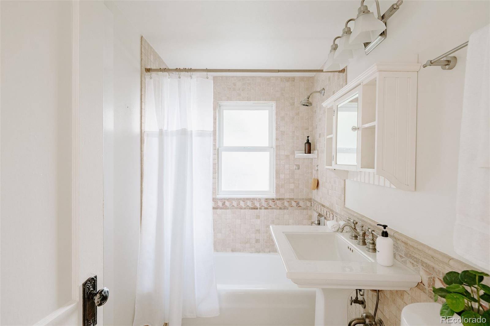 836 9th Street Boulder, CO 80302 - Photo 17 of 32 a bathroom with a sink a mirror and a bathtub
