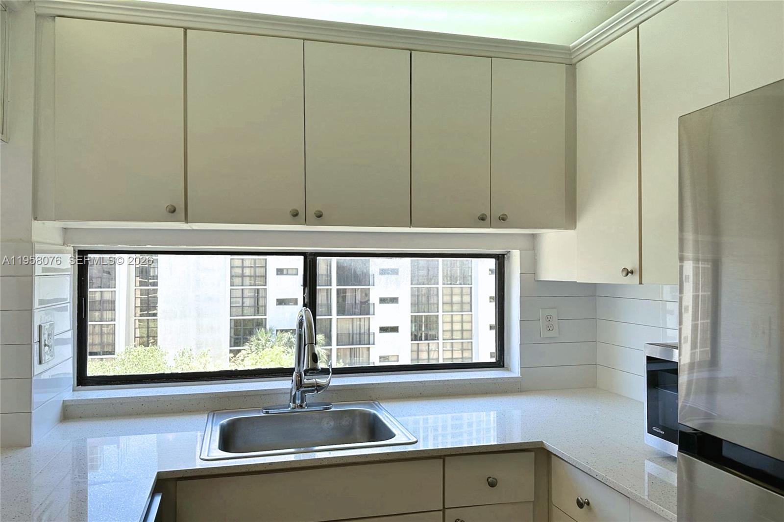 16919 North Bay Road, Unit 617 Sunny Isles Beach, FL 33160 - Photo 4 of 37 a kitchen with stainless steel appliances granite countertop white cabinets and a sink