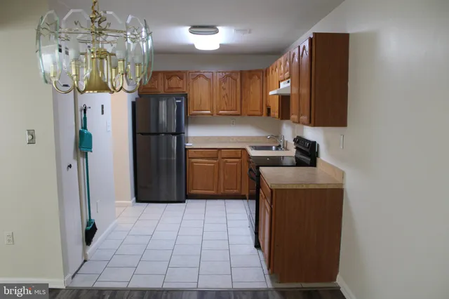 a kitchen with stainless steel appliances a refrigerator a sink a stove a microwave a counter top space and cabinets