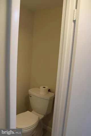 a white toilet sitting next to a small window