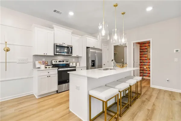 a kitchen with stainless steel appliances kitchen island granite countertop a sink stove and refrigerator