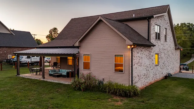 a view of a house with a big yard and large trees