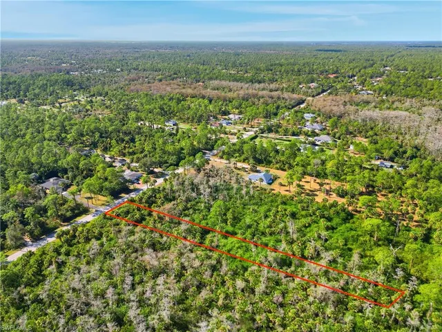 an aerial view of residential houses with outdoor space and trees