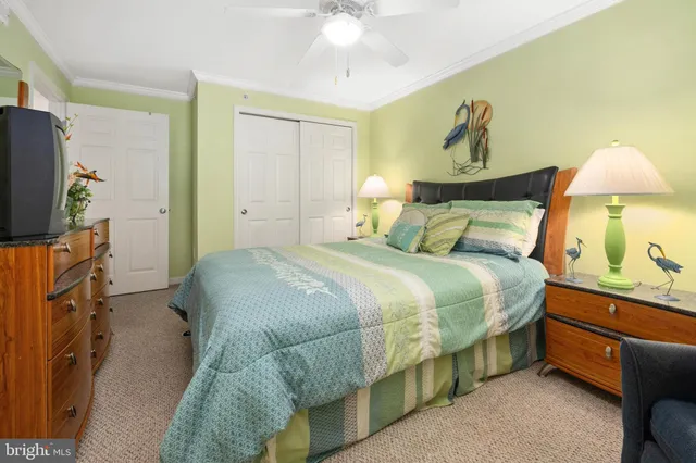 a bedroom with a bed and a flat tv screen on dresser