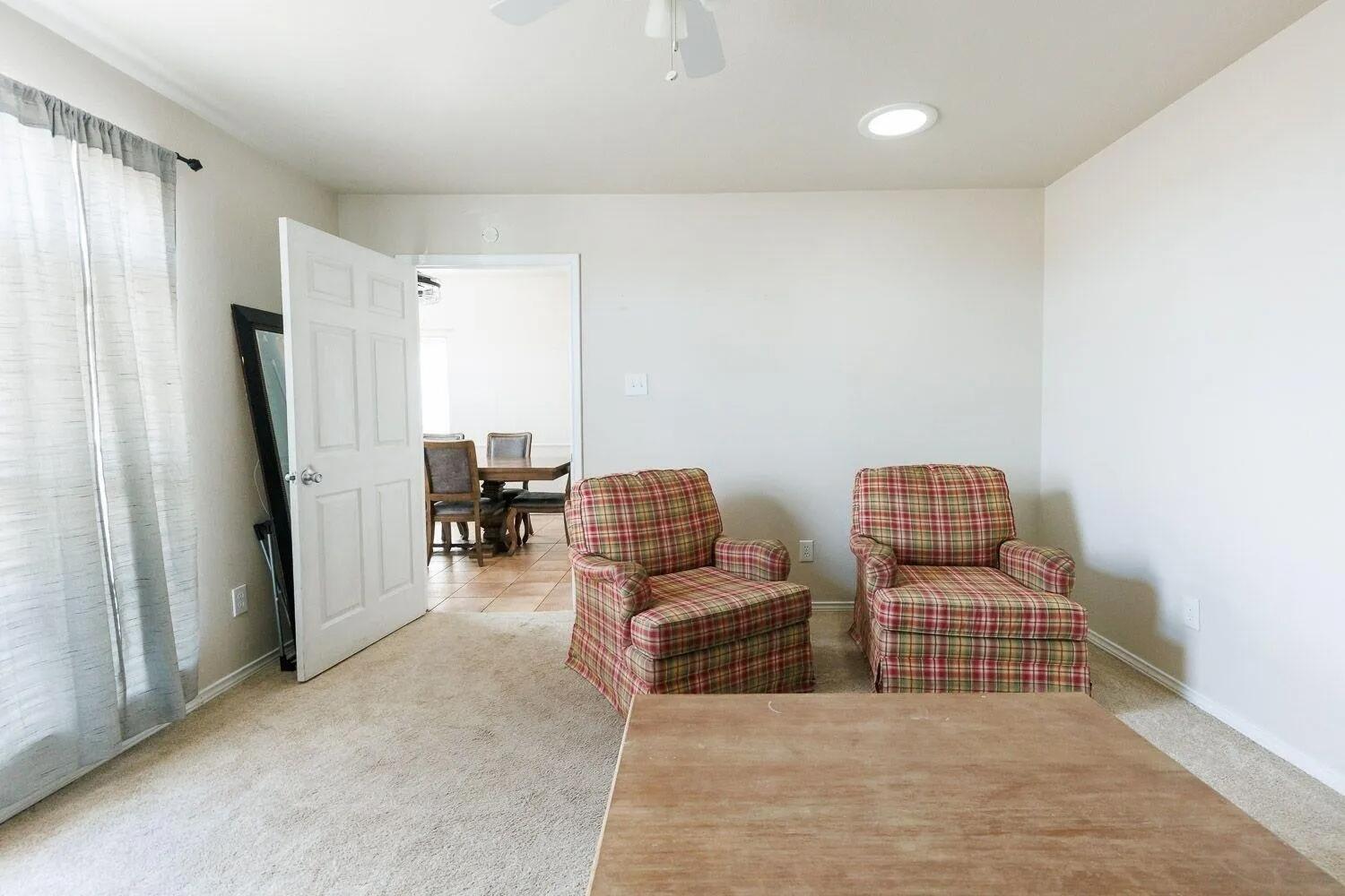 10602 Clinton Avenue Lubbock, TX 79424 - Photo 18 of 36 a living room with furniture and a flat screen tv