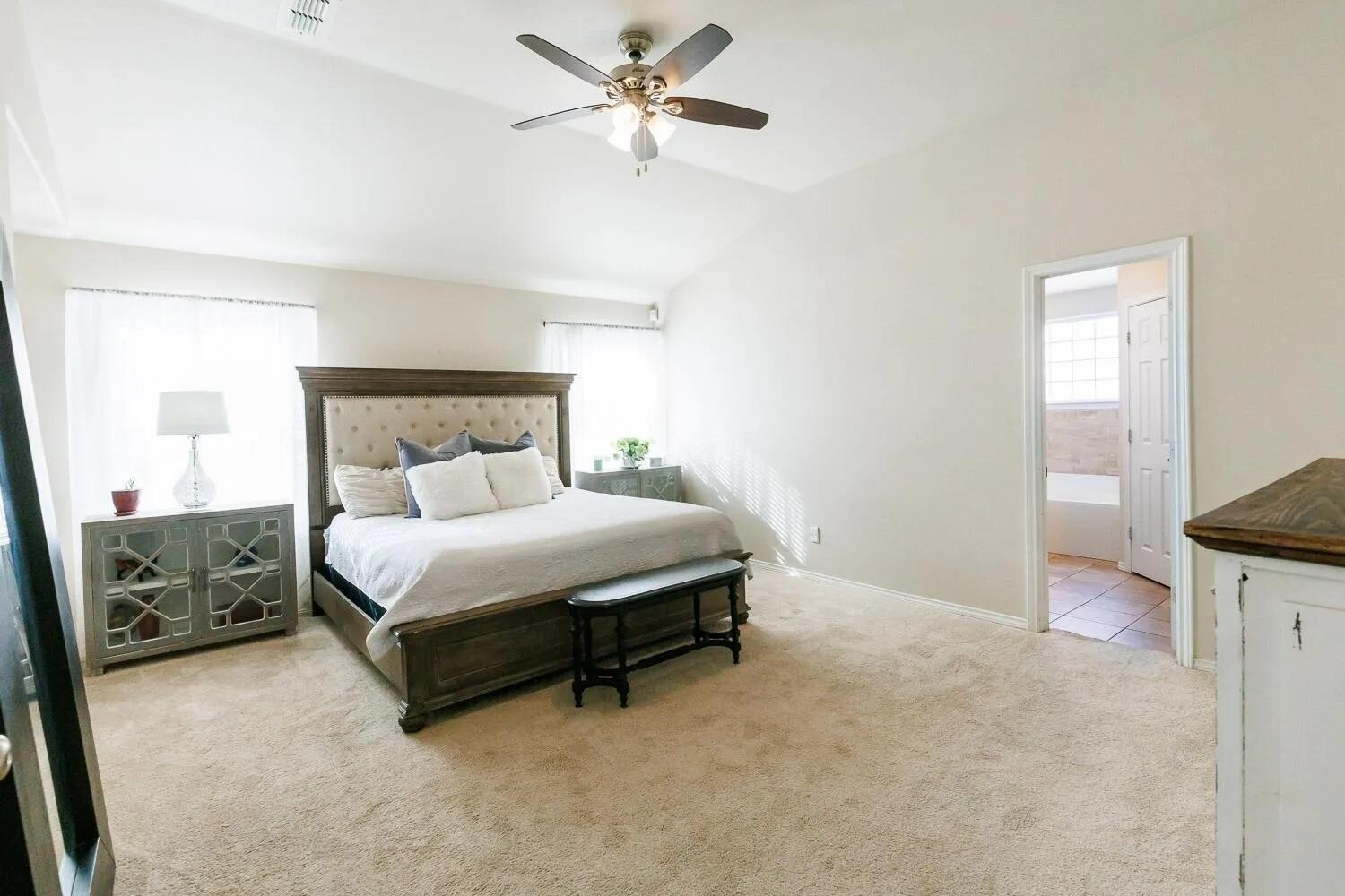 10602 Clinton Avenue Lubbock, TX 79424 - Photo 19 of 36 a bedroom with a bed and a chandelier
