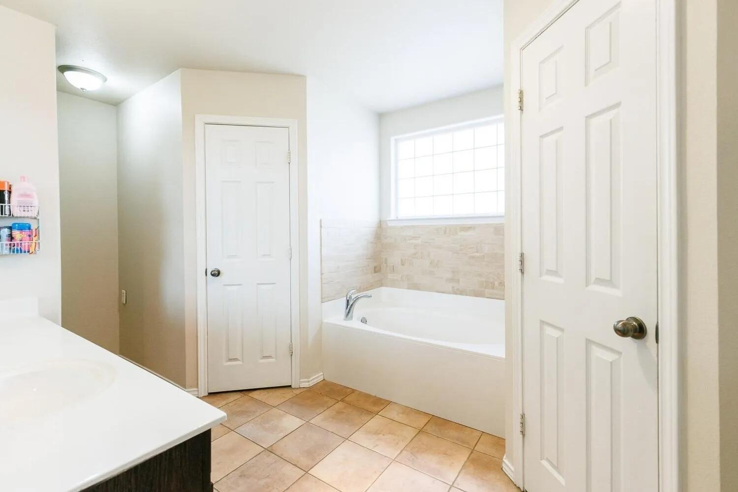 10602 Clinton Avenue Lubbock, TX 79424 - Photo 23 of 36 a bathroom with a bathtub and a shower