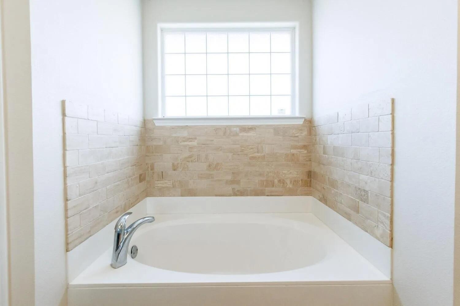 10602 Clinton Avenue Lubbock, TX 79424 - Photo 24 of 36 a bathroom with a bathtub