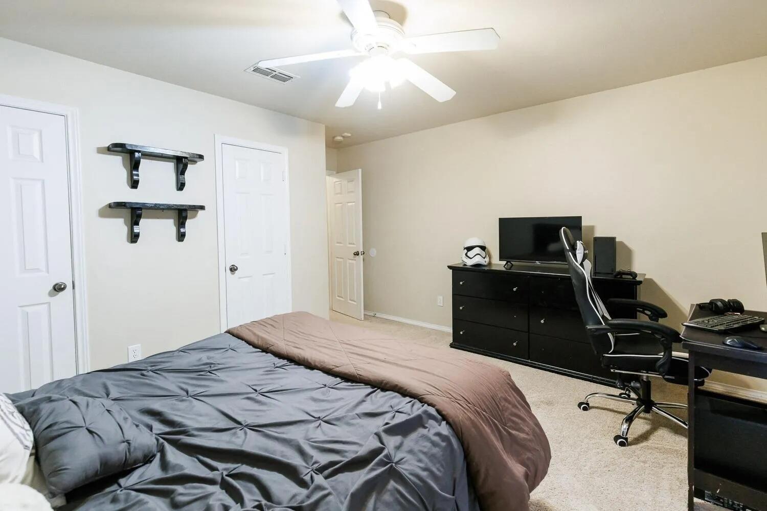 10602 Clinton Avenue Lubbock, TX 79424 - Photo 26 of 36 a bedroom with a bed and a chandelier