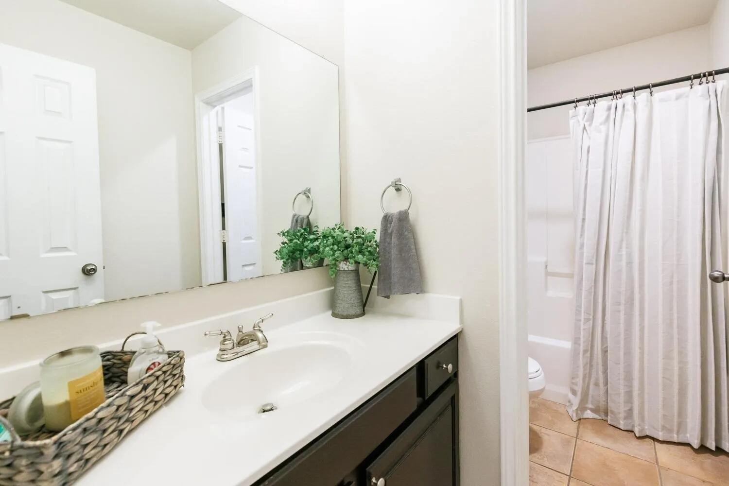 10602 Clinton Avenue Lubbock, TX 79424 - Photo 27 of 36 a bathroom with a granite countertop sink and a mirror