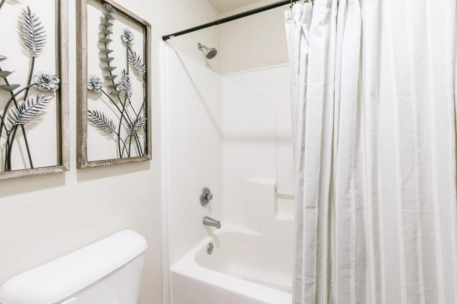 10602 Clinton Avenue Lubbock, TX 79424 - Photo 28 of 36 a bathroom with a shower curtain and a curtain