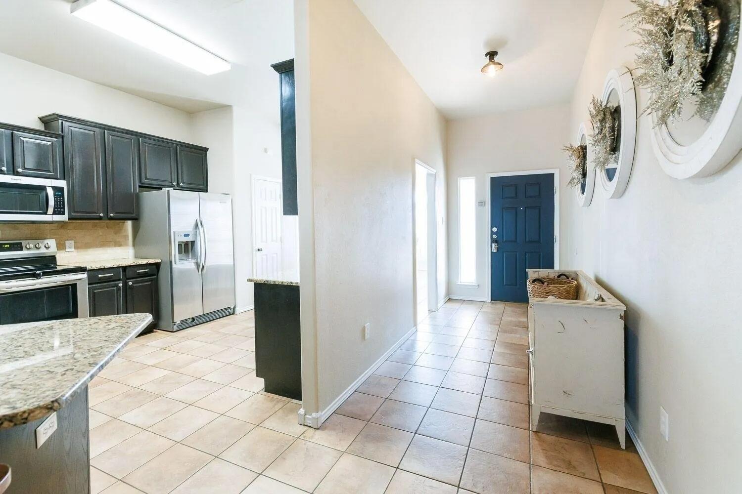 10602 Clinton Avenue Lubbock, TX 79424 - Photo 10 of 36 a kitchen with stainless steel appliances granite countertop a refrigerator and a stove